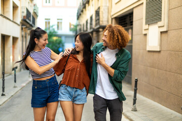 Fototapeta premium Happy friends walking and talking on a city street