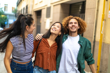 Happy students walking and talking on city street
