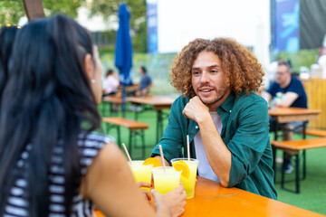 Friends enjoying drinks and conversation at outdoor beer garden