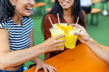 Friends toasting with tropical orange juice at outdoor party