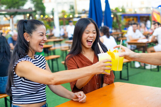 Happy friends toasting non alcoholic drinks at summer festival