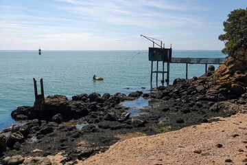 Vue sur l'oc&eacute;an et une cabane de p&ecirc;cheur depuis le rivage, avec tons vifs