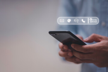 24-7 customer service support concept. Businessman hands holding digital contact icons, including email, phone, and chat, representing communication, accessibility, and online business care.
