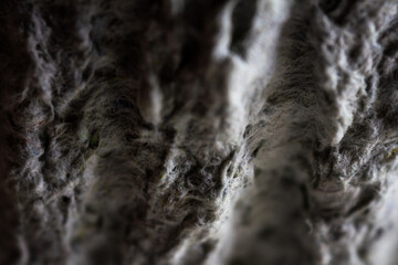 Extreme close up of old gray handmade paper clay with a structure and rough texture. Paper recycling. Selective soft focus, shallow depth of field.