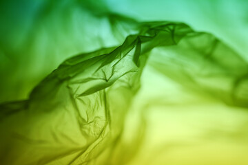 Extreme close up of yellow empty plastic bag background. The plastic surface is wrinkly and...