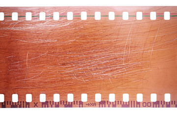 Dusty and grungy 35mm film texture or surface. Perforated scratched camera film isolated on white...