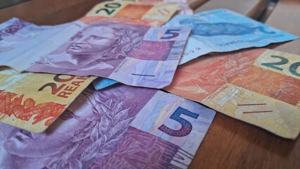 Brazilian real notes superimposed on a wooden background