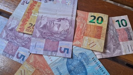 Brazilian real notes superimposed on a wooden background