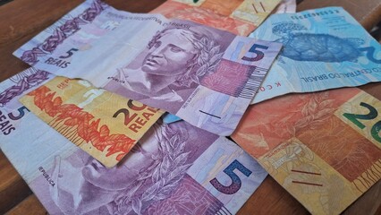 Brazilian real notes superimposed on a wooden background