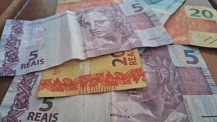 Brazilian real notes superimposed on a wooden background