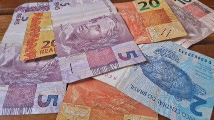 Brazilian real notes superimposed on a wooden background