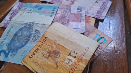 Brazilian real notes superimposed on a wooden background