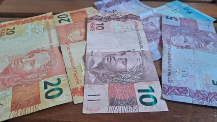 Brazilian real notes superimposed on a wooden background