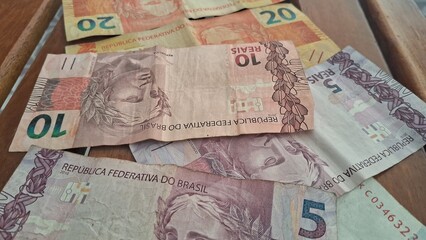 Brazilian real notes superimposed on a wooden background