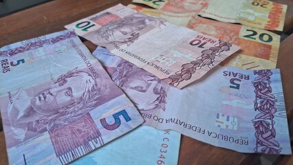 Brazilian real notes superimposed on a wooden background