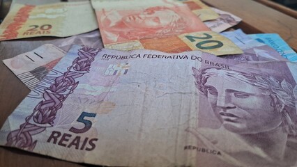 Brazilian real notes superimposed on a wooden background