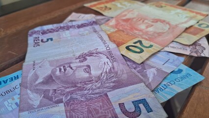 Brazilian real notes superimposed on a wooden background