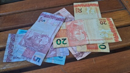 Brazilian real notes superimposed on a wooden background