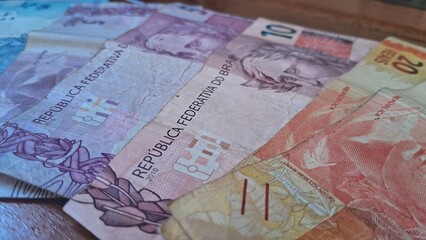 Brazilian real notes superimposed on a wooden background