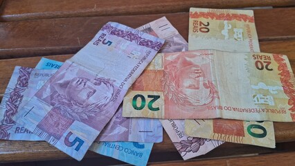 Brazilian real notes superimposed on a wooden background