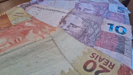 Brazilian real notes superimposed on a wooden background