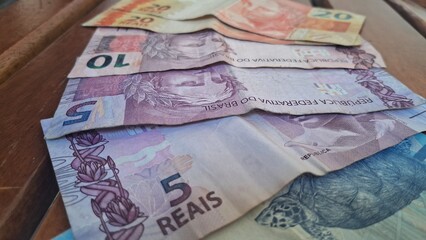 Brazilian real notes superimposed on a wooden background