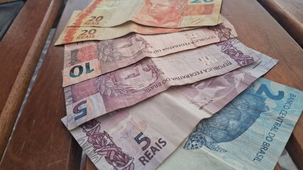 Brazilian real notes superimposed on a wooden background