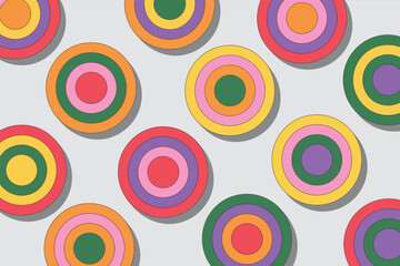 A pattern of colorful concentric circles with shadows on a light gray background forming a playful design