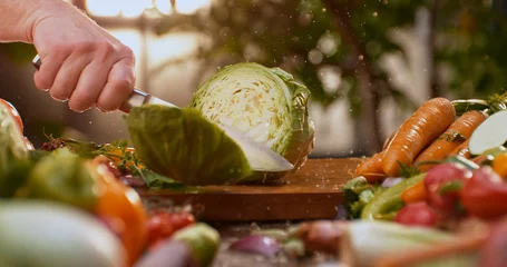 Fototapete Gemüse Chef cutting cabbage on wooden board with fresh vegetables  © Videophilia
