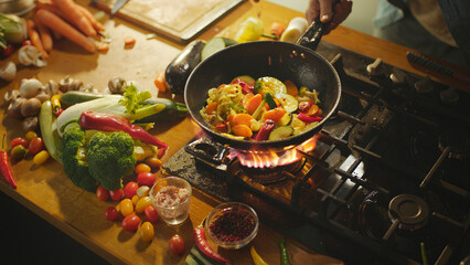 Chef preparing colorful vegetables in wok on gas stove