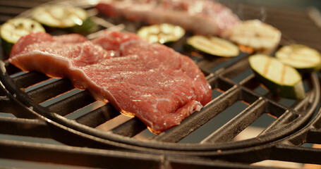 Fresh red meat and zucchini grilling on barbecue grill