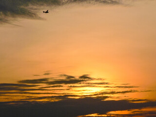 Small Aircraft Flying Over Sunrise Clouds