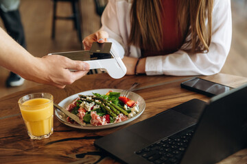 Wireless payment by using smartphone. Woman n the cafe restaurant