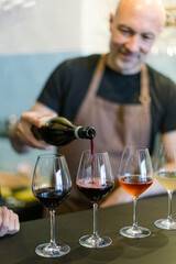 Sommelier pouring red wine into glass for wine tasting event