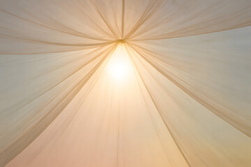 Shining canopy: A translucent fabric canopy drapes elegantly, framing a source of light, evoking a sense of serenity and artistic allure. 