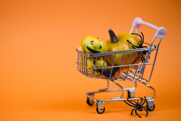 A Halloween Shopping Cart filled with colorful Pumpkins and creepy Spiders for celebrations