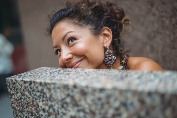 Smiling woman hiding behind granite block outdoors