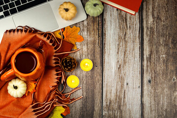 Fall-themed workspace concept. Top view photo of trendy cozy plaid, cup of coffee, notepad, autumn...