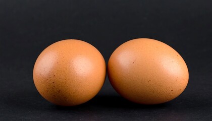 Two brown eggs on black background (1)