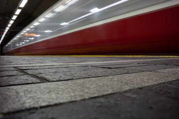 Low Angle View of Blurred Red Subway Train Speeding Past Underground Station Platform