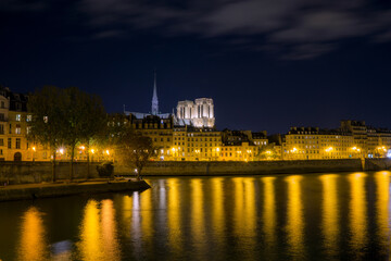 Illuminated Parisian Skyline with Notre-Dame Cathedral Reflected in the Seine River at Night