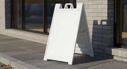 A blank white plastic A-frame sandwich board sign on a sidewalk for advertising.
