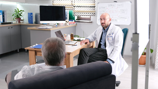 Two men are sitting in the doctor's office. The surgeon and the orthopedist discuss the case with the patient. The pensioner came to see a therapist