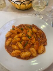 Closeup image of a plate of gnocchi with a Bolognese sauce