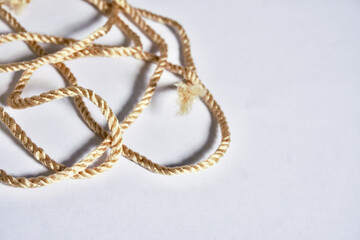 Close up thin short brown thread rope string object isolated on horizontal white background with empty copy space for text.