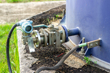 Industrial liquid storage tank monitoring system with pressure sensor installed on a blue container...