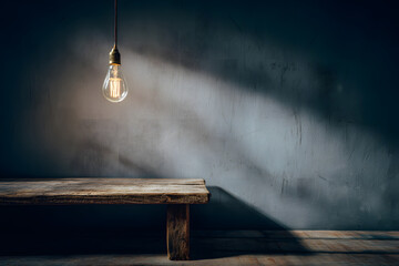 Obraz premium empty wooden table under dimly lit light bulb suggesting enigmatic atmosphere shadows on blank wall