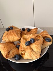 Homemade puff pastry turnovers filled with cottage cheese apples and blueberries in home kitchen. 