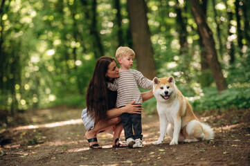 Obraz premium Mother with her son and Shiba Inu dog are in the forest
