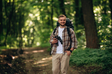 Male tourist is with backpack in the forest